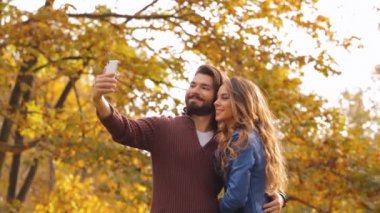 Sonbahar park, smartphone kullanarak genç Çift.