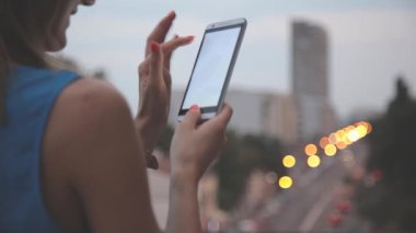 Bokeh bulanık şehir zemin üzerine Smartphone kullanan kadın.