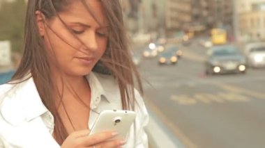 Genç kadın manifatura köprüde smartphone kullanarak arkadaşlar