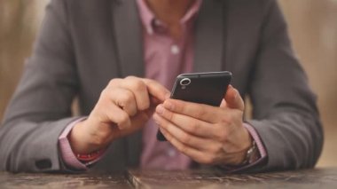 Genç adam manifatura mesaj ile smartphone Sonbahar Park görünümünü kırpılmış