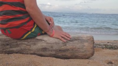 Çizgili tişört sahil günlüğüne oturan adam