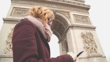 Kadın gözlük Paris mimari özgeçmişlerine smartphone kullanarak.
