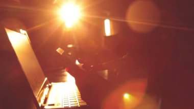 Parlak güneş ışığı ile karanlık odada smartphone ve dizüstü kullanarak eller