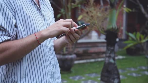 Vista Recortada Del Hombre Utilizando Teléfono Inteligente Jardín — Vídeos de Stock