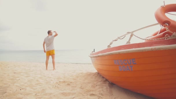Hombre Orillas Del Mar Con Bote Rescate Rojo — Vídeo de stock