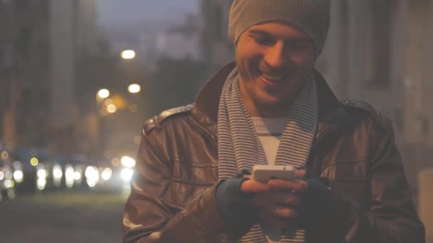 Hombre Gorro Sombrero Usando Teléfono Inteligente Sobre Fondo Urbano Borroso — Vídeos de Stock