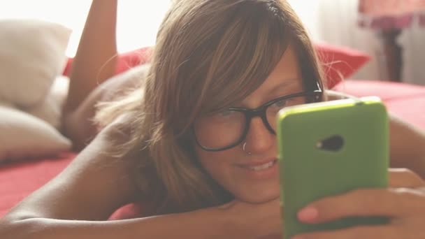 Mujer Bonita Gafas Usando Teléfono Inteligente Acostado Cama — Vídeo de stock