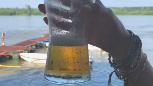 Mano Femenina Sosteniendo Vaso Cerveza Fría Sobre Fondo Con Río — Vídeo de stock