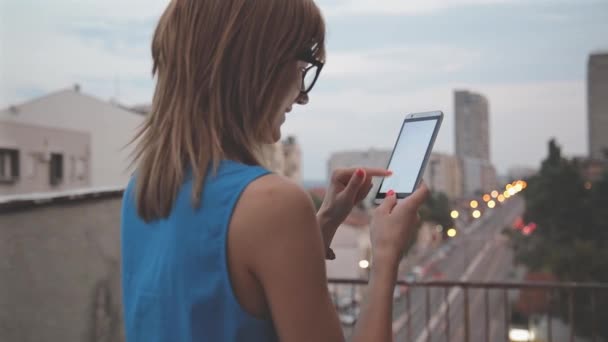 都市の背景をぼかしにスマート フォンを用いたガラスの女 — ストック動画