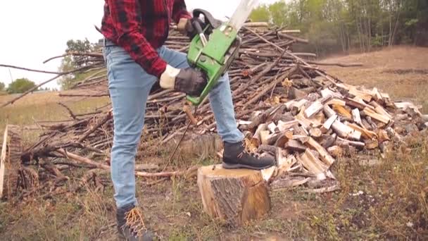 有链锯和一堆砍伐的树林的伐木工人 — 图库视频影像