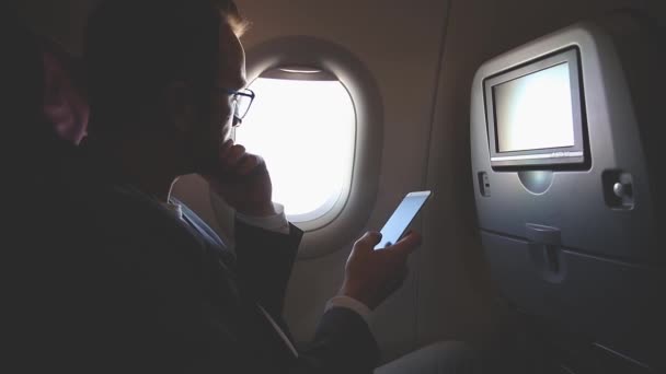 Hombre Usando Smartphone Viajando Avión — Vídeo de stock