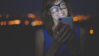 Açık, akıllı telefon kullanan genç kadın arka plan nehirde köprüden.