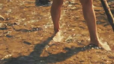 Genç kadın geçiş Stream stick kullanarak ormandaki alttan görünüm