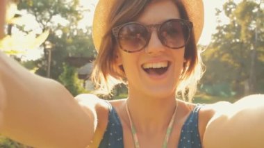 Kadın şapka ve gözlük yapma video açık smartphone kullanarak