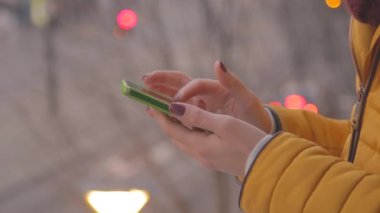 Bokeh bulanık şehir zemin üzerine Smartphone kullanan kadın.