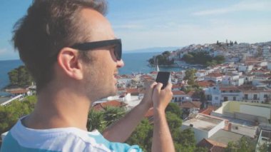 Çizgili tişört erkekte yaz aylarında kullanma smartphone kentsel arka plan bulanık