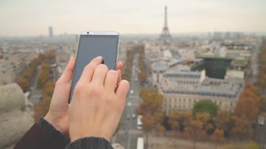 Eyfel Kulesi arka plan üzerinde Smartphone kullanarak eller