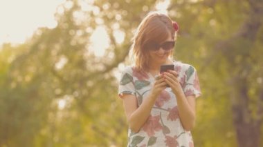 Cep telefonuyla bahçede gözlük güzel kadın