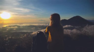 Genç kadın ejoying günbatımı dağ başında rahatlatıcı