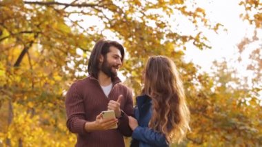 Sonbahar park, smartphone kullanarak genç Çift.