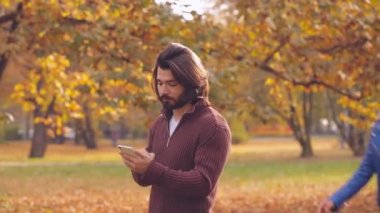 Sonbahar park, smartphone kullanarak genç Çift.