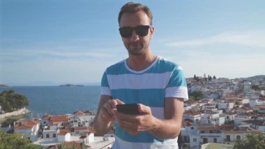Çizgili tişört erkekte yaz aylarında kullanma smartphone kentsel arka plan bulanık
