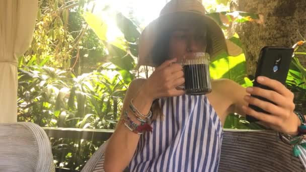 Genç Kadın Elbise Şapka Manifatura Smartphone Kullanarak Koltukta Oturup Çay — Stok video