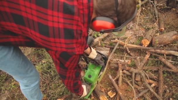 有链锯和一堆砍伐的树林的伐木工人 — 图库视频影像