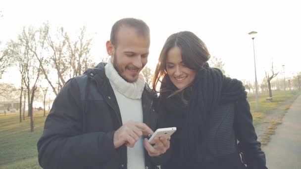 Pareja Usando Teléfono Inteligente Juntos Fondo Urbano Borroso — Vídeo de stock