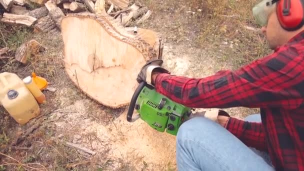 Skogshuggare Med Motorsåg Och Högen Skurna Woods — Stockvideo