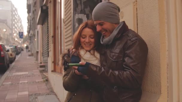 Pareja Usando Smartphone Juntos Por Calle — Vídeos de Stock