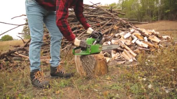 Skogshuggare Med Motorsåg Och Högen Skurna Woods — Stockvideo