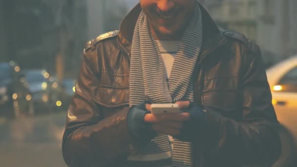 Άνθρωπος Καπέλο Beanie Χρησιμοποιώντας Smartphone Θολή Αστικό Φόντο — Αρχείο Βίντεο