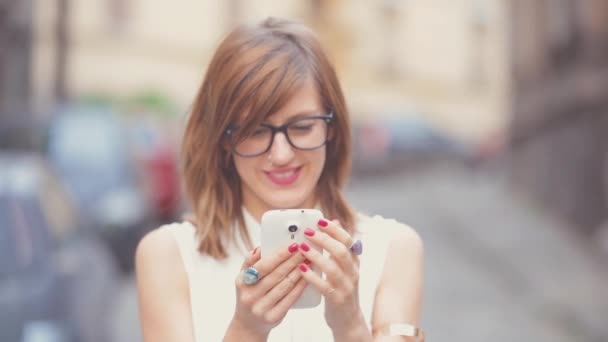 Mujer Blusa Blanca Usando Smartphone Sobre Fondo Urbano Borroso — Vídeo de stock