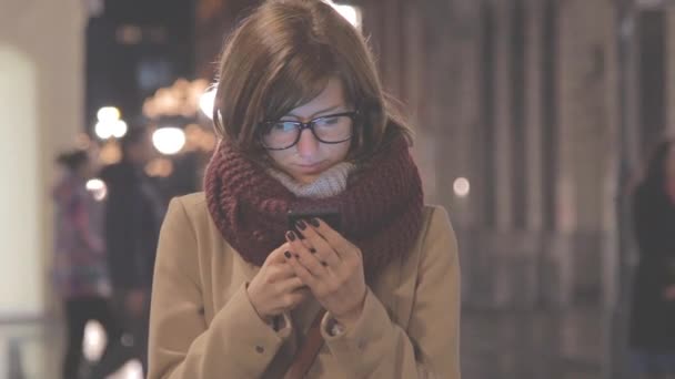 Žena Plášti Snood Pomocí Smartphone Rozmazané Městské Pozadí Bokeh — Stock video