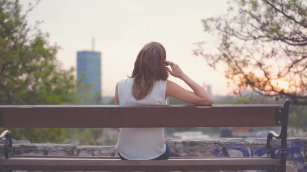 Mujer Descansando Banco Parque Atardecer — Vídeos de Stock