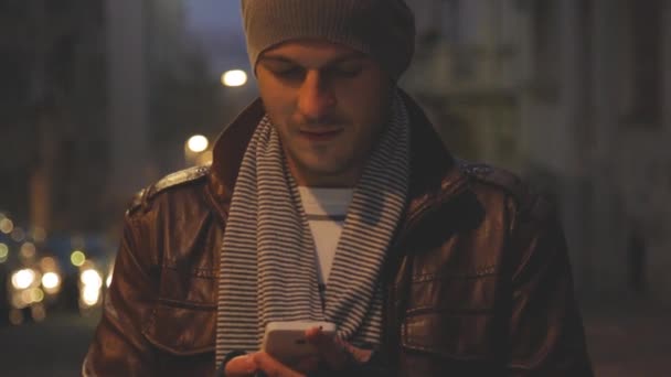 Νεαρός Άνδρας Δερμάτινο Μπουφάν Και Καπέλο Γραπτών Μηνυμάτων Μήνυμα Smartphone — Αρχείο Βίντεο