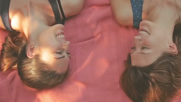 Zwei Frauen Liegen Auf Rosa Decke Park — Stockvideo