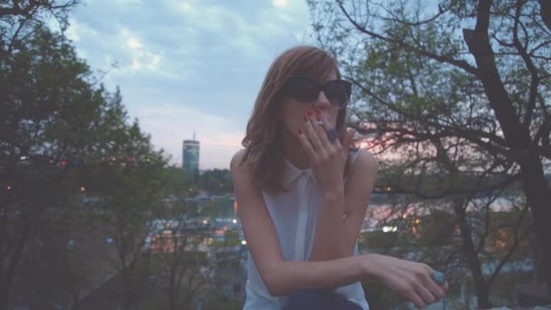 公園でタバコを吸ってサングラスの女 — ストック動画