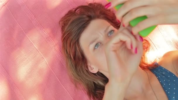 Femme Utilisant Smartphone Pose Sur Une Serviette Rose Extérieure — Video