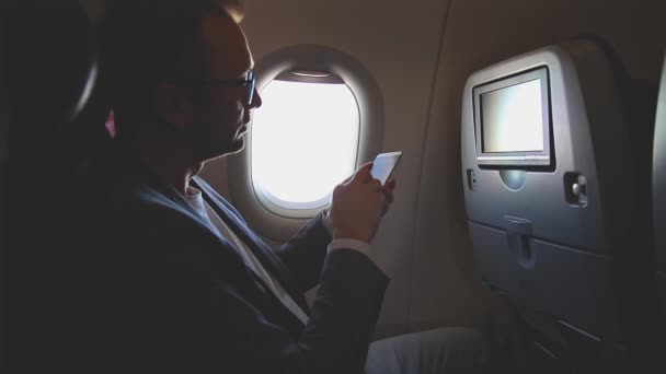 Hombre Usando Smartphone Viajando Avión — Vídeos de Stock