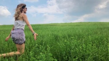 Kız bir yeşil çim sahada atlama. Ağır çekim.