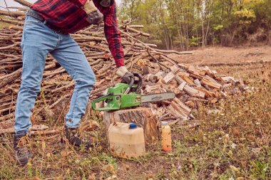 Testere ile kesme woods yığını ile oduncu.