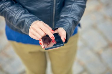 Sokakta modern akıllı telefon kullanan bir kadın..