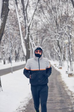 Soğuk bir kış karlı gün açık havada adam jogging.
