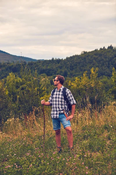 Hiker posing with knife on the belt in a meadow. — Stock Photo, Image