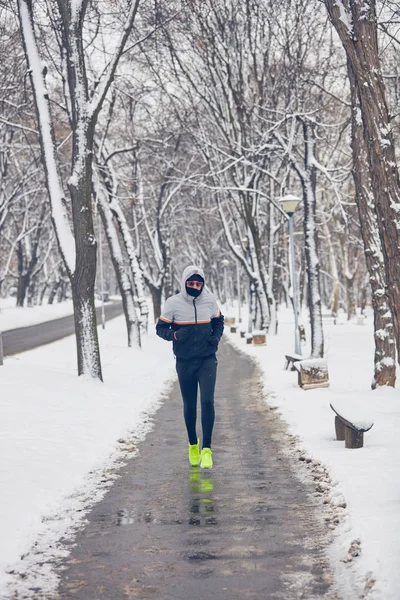 Homme jogging dans un hiver froid journée enneigée en plein air . — Photo