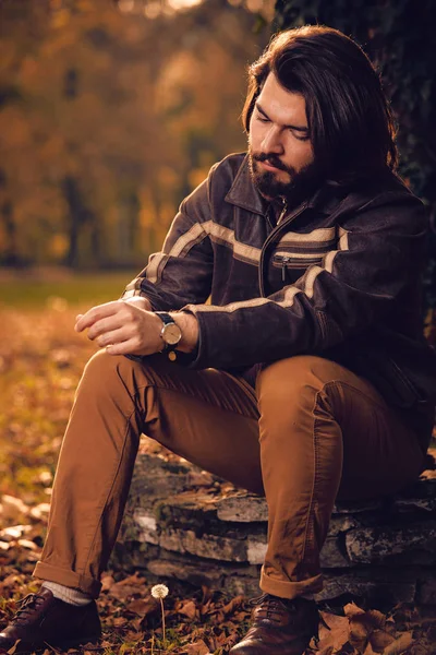 Man looking at hand watch in the park. — Stock Photo, Image