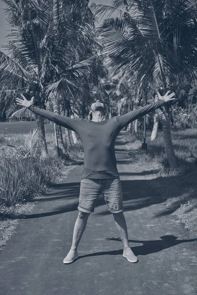 Homem desfrutando de clima tropical com os braços abertos . — Fotografia de Stock