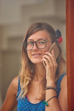 Evde akıllı telefon kullanan genç kadın. OU 'dan pencere yansıması